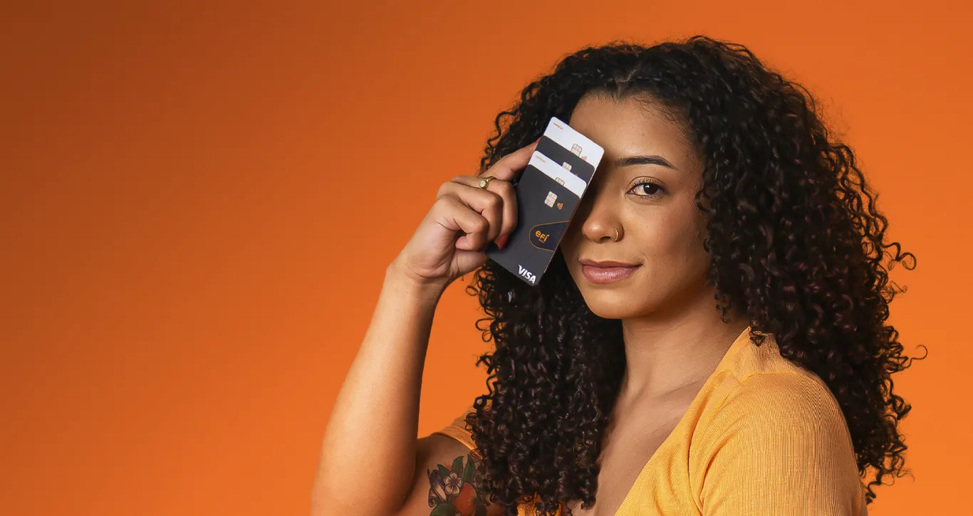 Pessoa segurando tipos de cartões do Efí Bank