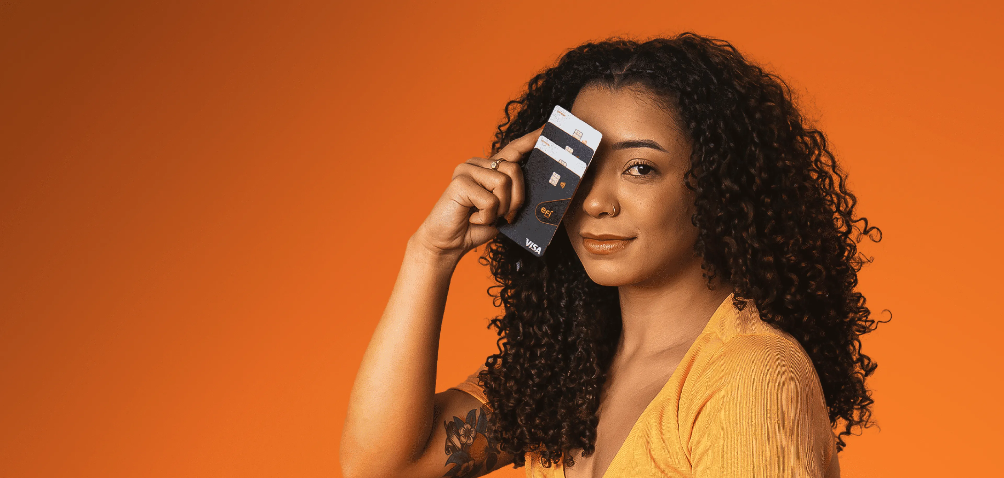 Pessoa segurando tipos de cartões do Efí Bank